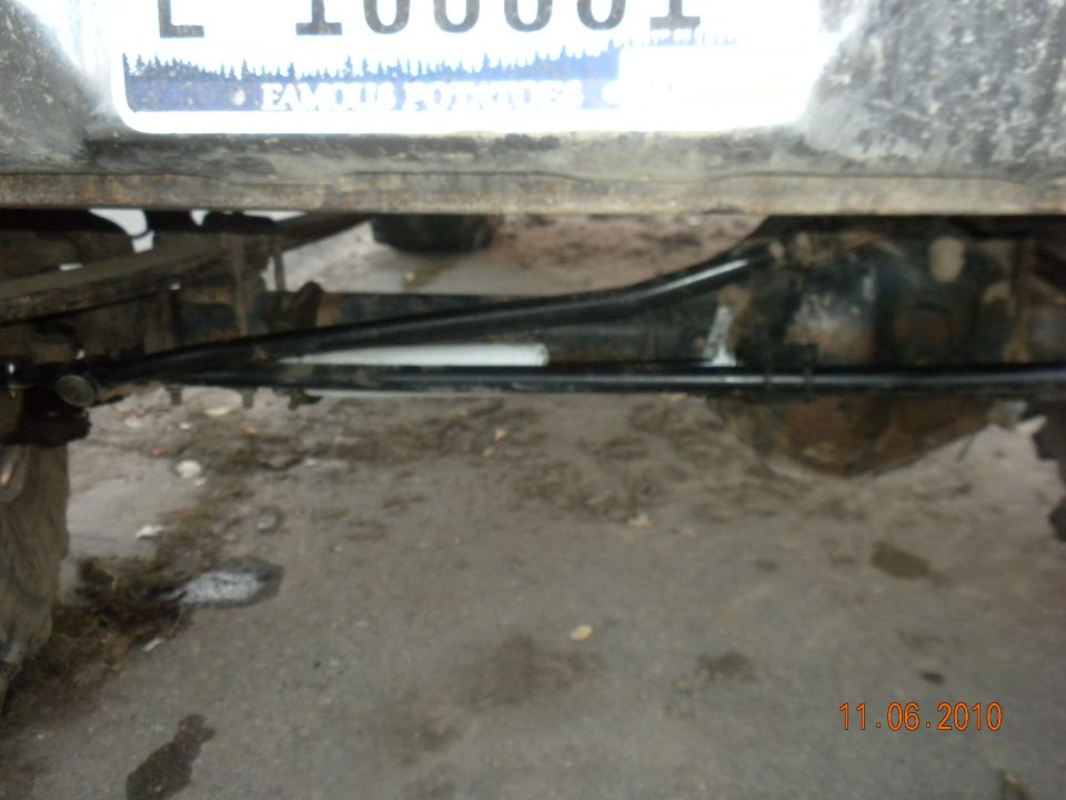 Rear axle assembly and suspension parts of a vehicle, with a license plate visible above