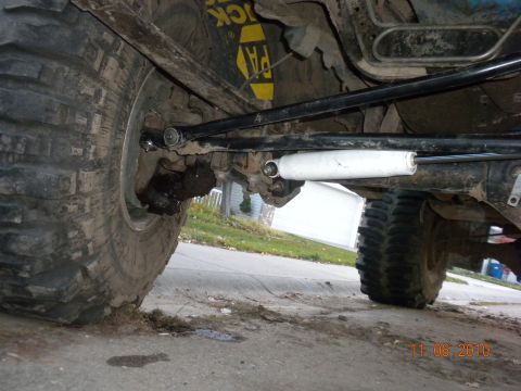 1989 Ford Bronco - Close-up view of the undercarriage, showing large tires and suspension components, with a visible shock absorber.