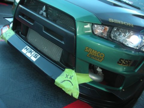 1998 Ford Crown Victoria - teal front end of a Mitsubishi Lancer Evolution showing a front-mount intercooler and HKS, Samco Sport, and SSR sponsor decals.