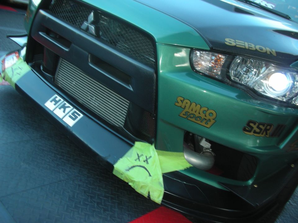 Teal Mitsubishi Lancer Evolution front end with HKS, Samco and SSR decals