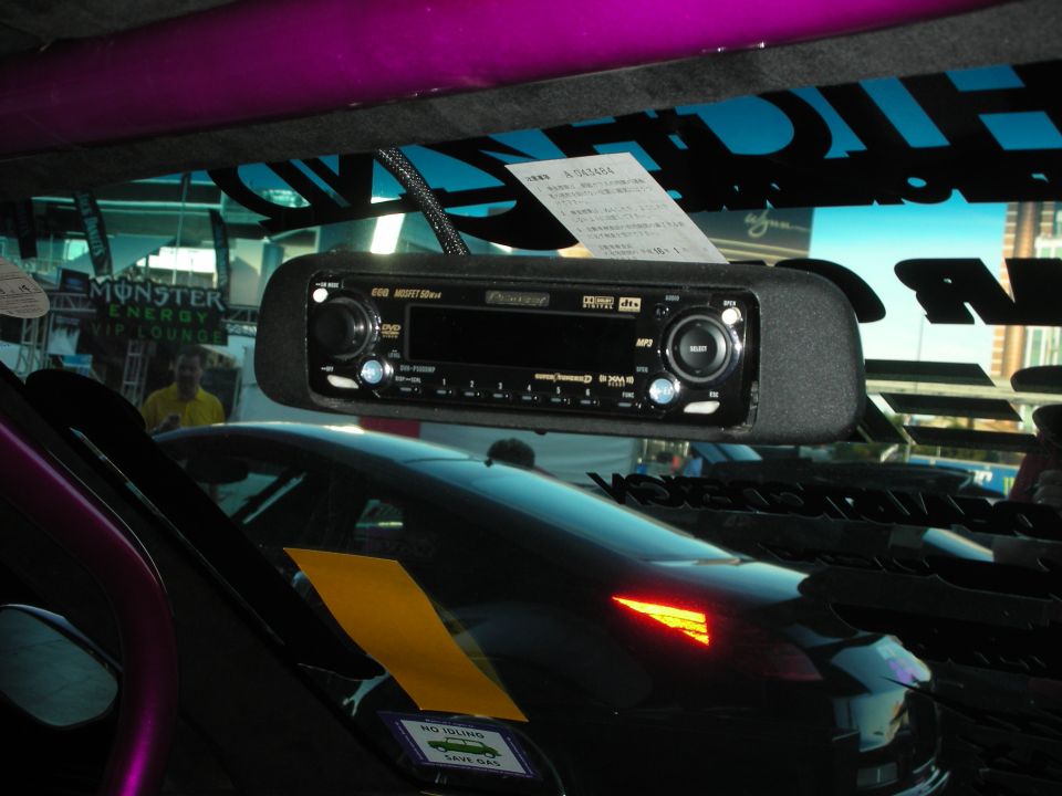 Rearview-mirror media player on windshield with purple car reflected below