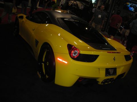 1998 Ford Crown Victoria - Rear three-quarter view of a yellow Ferrari 458 with a black roof panel and black wheels under indoor show lighting.