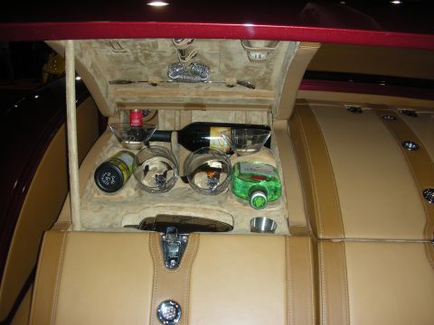1998 Ford Crown Victoria - built-in luggage-style bar compartment in a car's rear, holding a wine bottle, martini glasses and a green liqueur bottle in suede-lined tr…