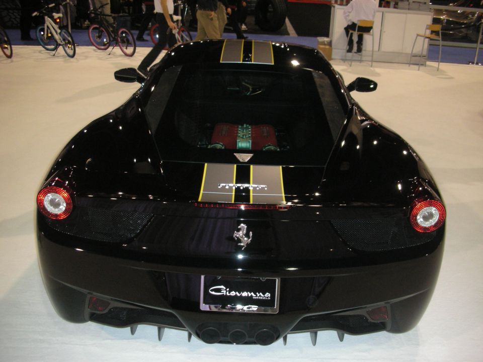 Rear of black Ferrari 458 with gold racing stripes and Giovanna plate