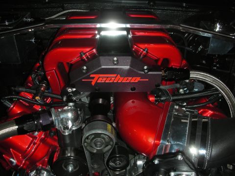 1998 Ford Crown Victoria - polished engine bay featuring a glossy red intake manifold with a Techco-branded cover and braided steel fuel lines.