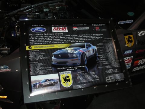 1998 Ford Crown Victoria - backlit spec display card for a 2007 Shelby Terlingua Mustang showing build details and photos of the silver and red race car.