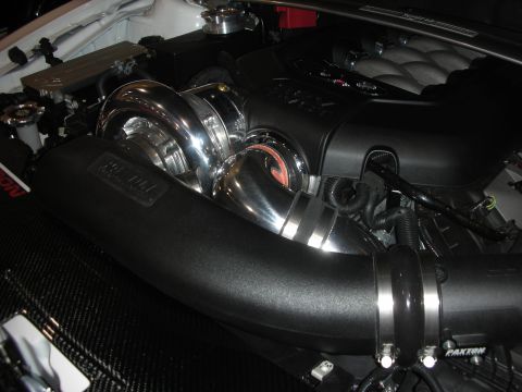 1998 Ford Crown Victoria - modified engine bay with black Paxton intake ducting, polished supercharger and chrome piping in a white engine compartment.