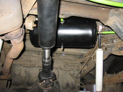 1995 Ford Bronco - Underside view of a vehicle's suspension system, an air tank and exhaust pipe.
