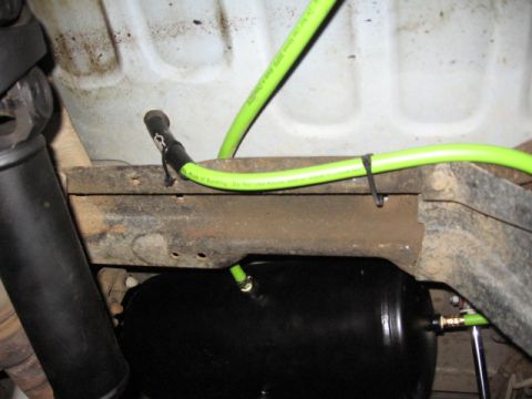 1995 Ford Bronco - Underside view of a vehicle showing an installed air tank and associated plumbing.