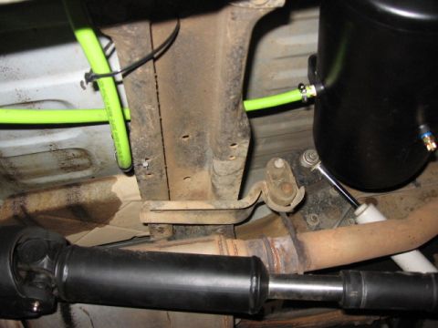 1995 Ford Bronco - Underbody view shows an onboard air tank and green hoses connected to the vehicle's frame, with a driveshaft visible.