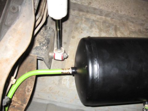 1995 Ford Bronco - Underside view of a vehicle's suspension system, showing an air tank and shock absorber.