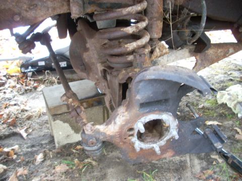 1996 Ford F-150 - Close-up view of heavily corroded front suspension components, suggesting a need for repair or replacement.