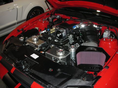 1998 Ford Crown Victoria - backlit spec display card for a 2013 Shelby GT500 listing performance, exterior and interior mods beside photos of the red convertible.