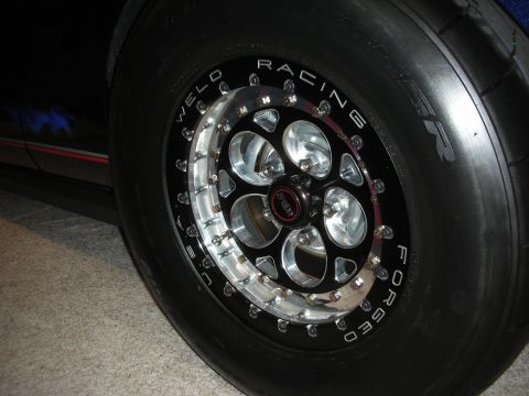 1998 Ford Crown Victoria - polished Weld Racing Forged beadlock wheel fitted with a smooth drag slick tire on a dark-colored car.