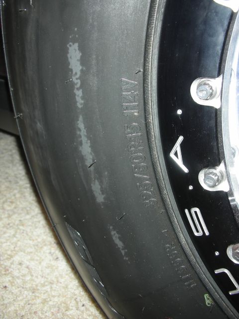 1998 Ford Crown Victoria - Detail of a wide low-profile racing tire sidewall reading 325/30R15 mounted on a black-and-chrome wheel.