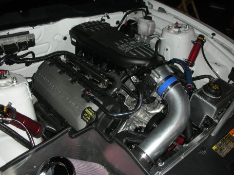 1998 Ford Crown Victoria - supercharged engine with polished intake piping and blue couplers sitting in a detailed white engine bay.