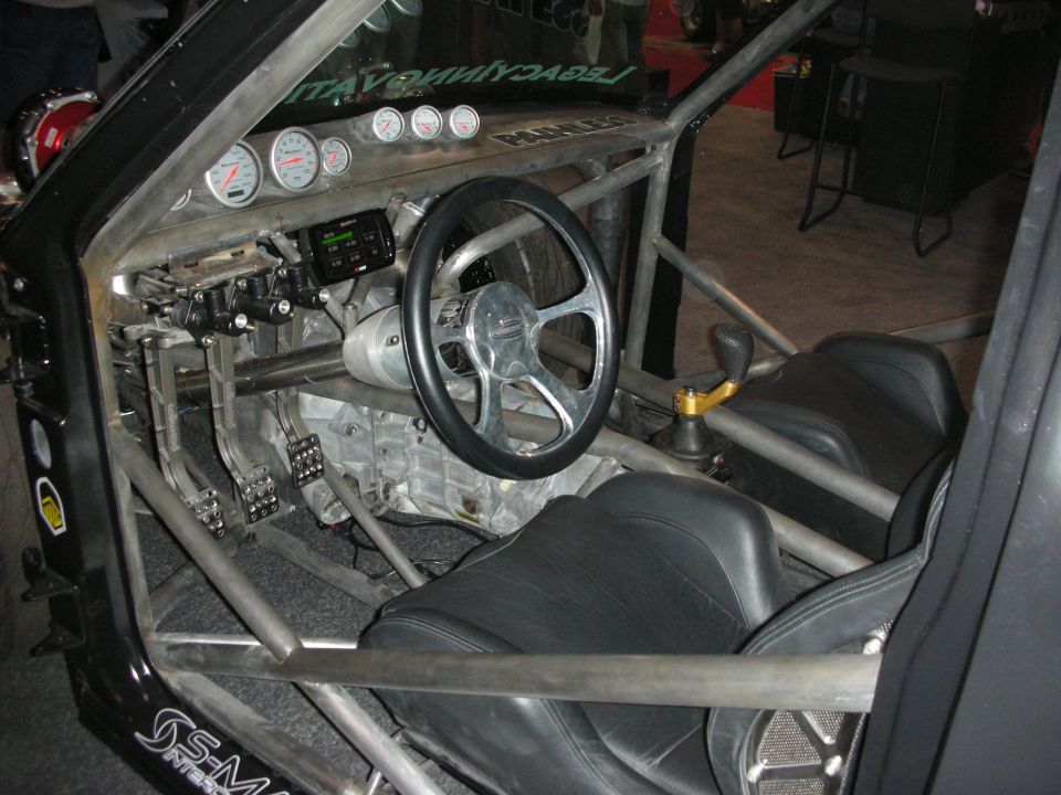 Tube-frame race car cockpit with roll cage, gauges and bucket seats