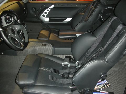 1998 Ford Crown Victoria - black custom interior featuring billet-trimmed door panels, a three-spoke wheel and harness-equipped racing bucket seats.