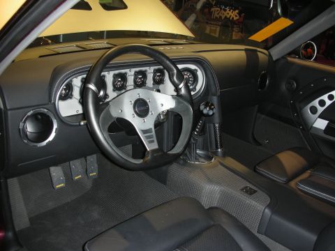 1998 Ford Crown Victoria - custom car cockpit with a polished billet dashboard, row of round gauges and a small leather-rimmed steering wheel.