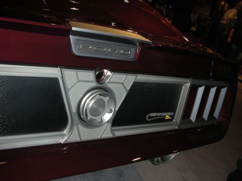 1998 Ford Crown Victoria - Close-up of a maroon custom car's rear panel showing recessed FORD lettering, mesh inserts and a central billet fuel cap.