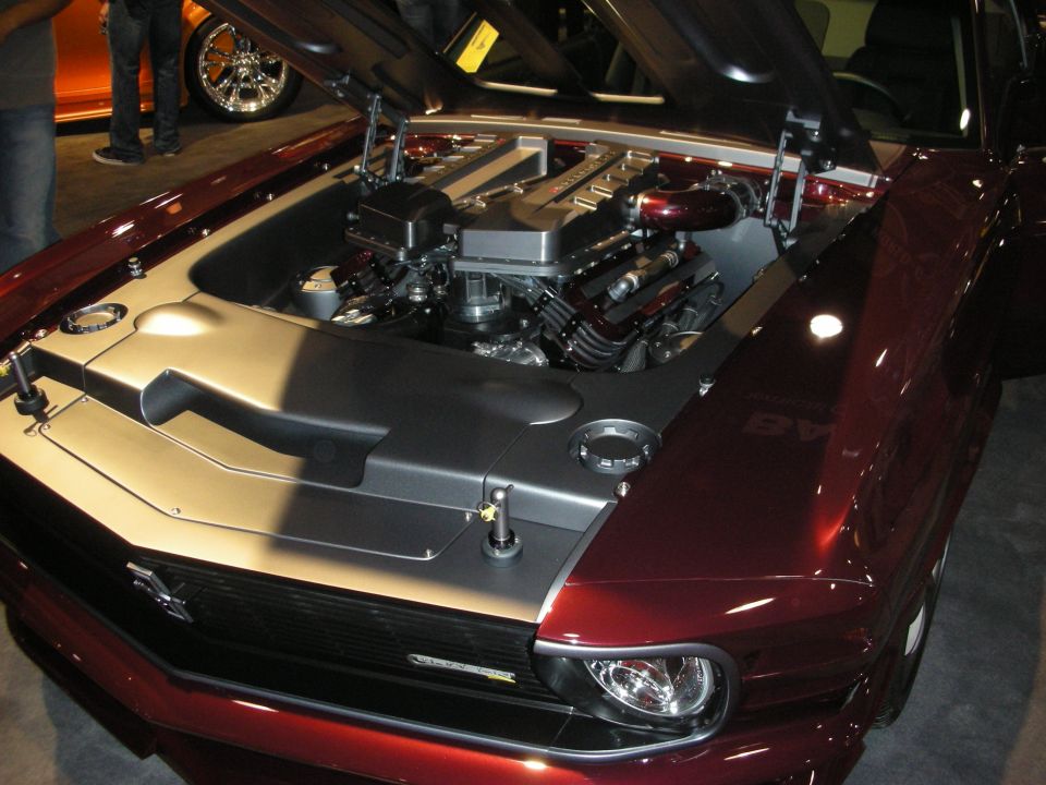 Modern DOHC engine under the hood of a maroon custom muscle car