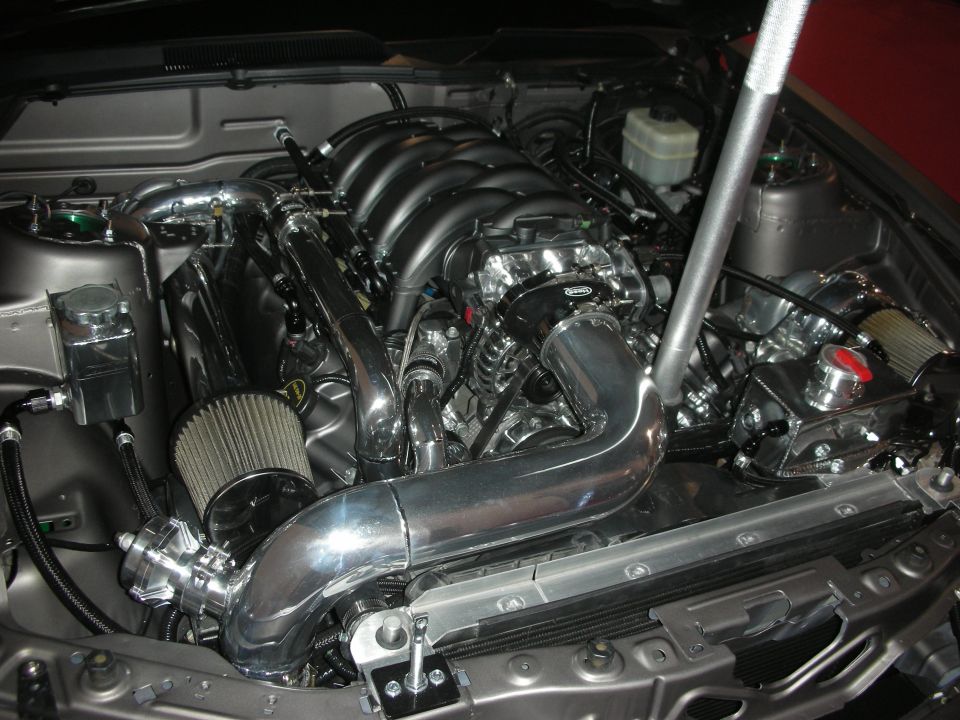 V8 engine bay with polished cold-air intake tubes and master cylinder