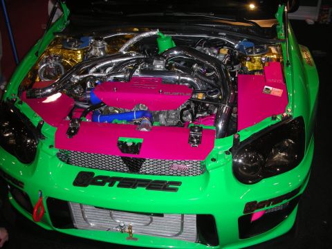 1998 Ford Crown Victoria - lime-green show car with its hood open reveals a pink-painted engine bay, chrome boost piping, and a front-mount intercooler.