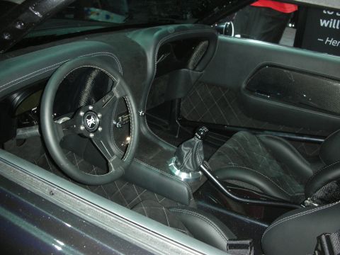 1998 Ford Crown Victoria - custom dark car interior with a carbon-fiber-rimmed steering wheel, exposed shifter, and diamond-stitched leather seats.