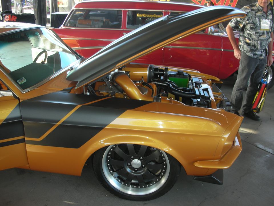 Gold and black custom muscle car with open hood and engine bay