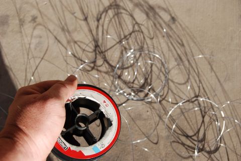 1982 Ford Bronco - A spool of fishing line lies on a concrete surface, with tangled line scattered around it.