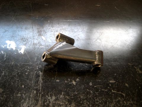 1996 Ford Bronco - A close-up view of a custom metal suspension component, likely for an off-road vehicle, showing its fabricated structure.