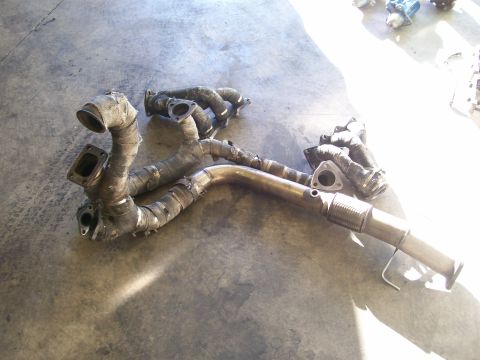 1995 Ford Probe - Exhaust manifold part shown on a concrete surface, with visible heat wrap and flex pipe sections.