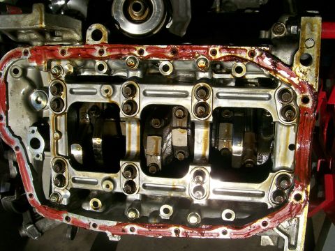 1995 Ford Probe - The engine's oil pan gasket shows signs of sealant application, indicating recent work or a need for repair.
