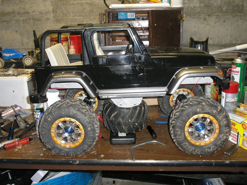 Black remote control monster truck with oversized tires and gold rims