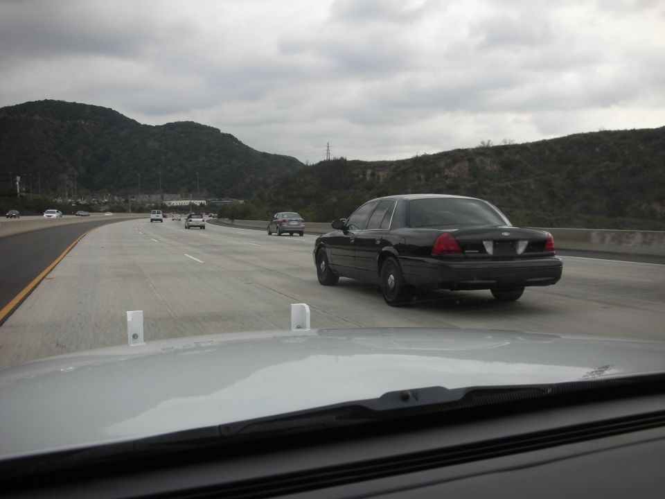 Black 2004 Ford Crown Victoria from rear on highway