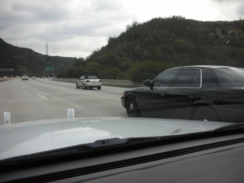 Black 2004 Ford Crown Victoria driving on highway next to other cars