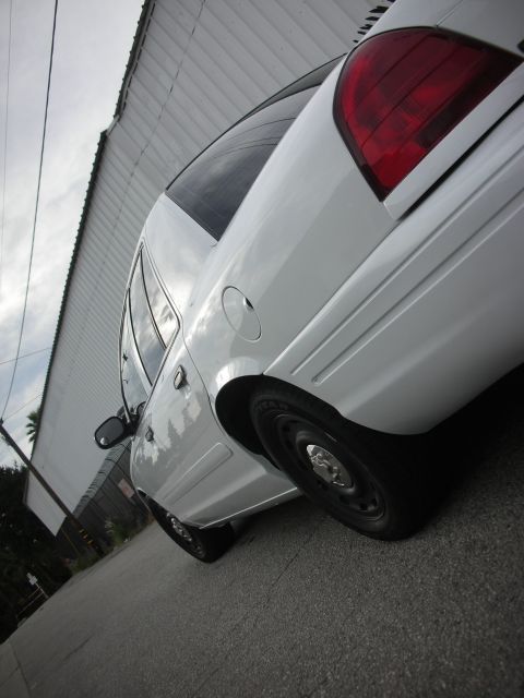 2004 Ford Crown Victoria - Rear view of a white 2004 Ford Crown Victoria, showing its taillight and body lines.