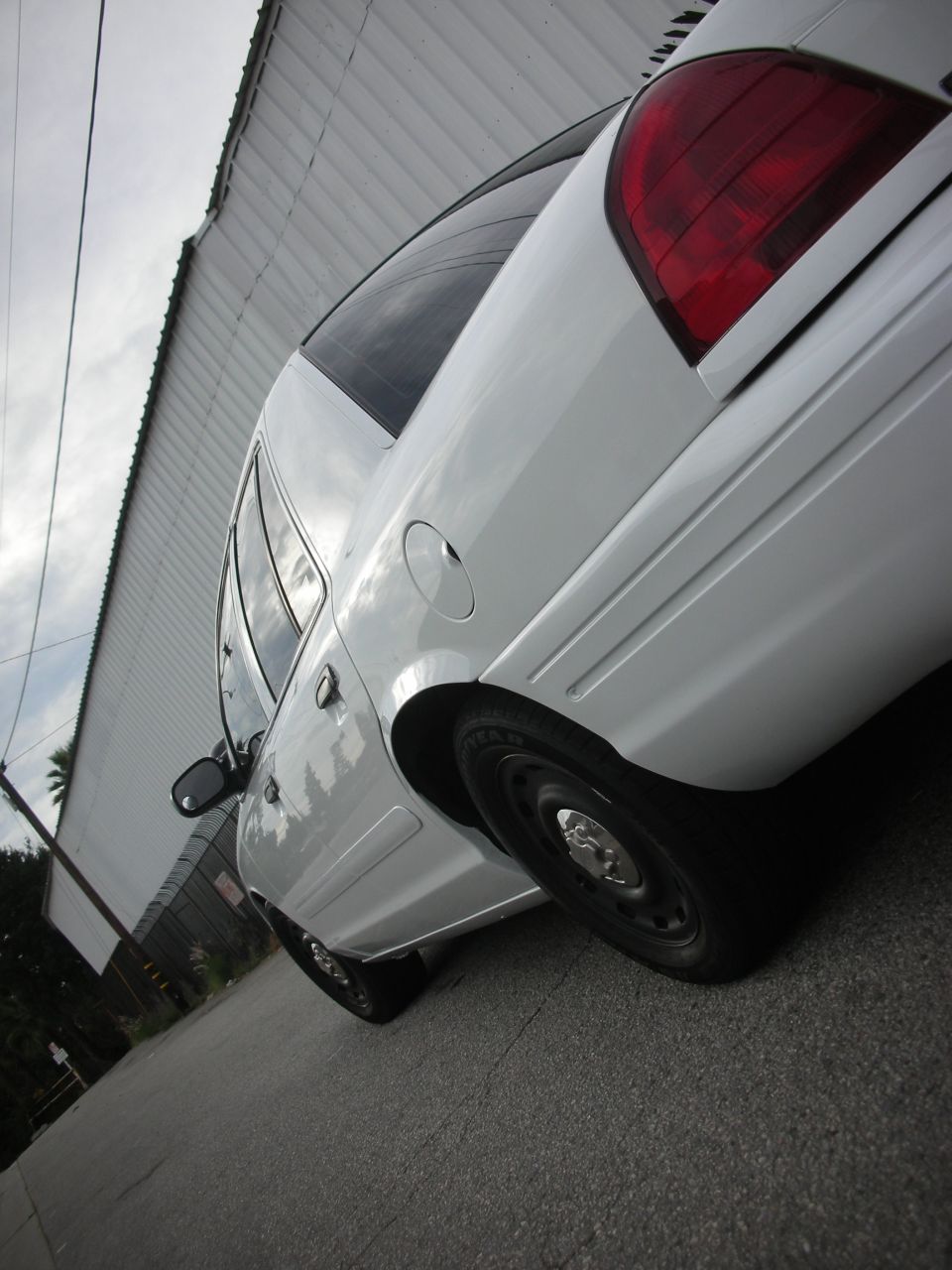 White 2004 Ford Crown Victoria, rear quarter view, parked on asphalt
