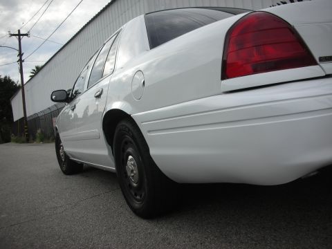 2004 Ford Crown Victoria - Rear view of a white 2004 Ford Crown Victoria, showing its distinctive taillight and body lines.