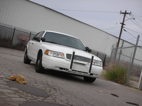 2004 Ford Crown Victoria - Front view of a white 2004 Ford Crown Victoria police car with a push bar.