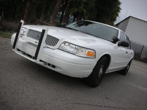 2004 Ford Crown Victoria - White Ford Crown Victoria police interceptor fitted with a steel push bumper, photographed low from the front quarter.