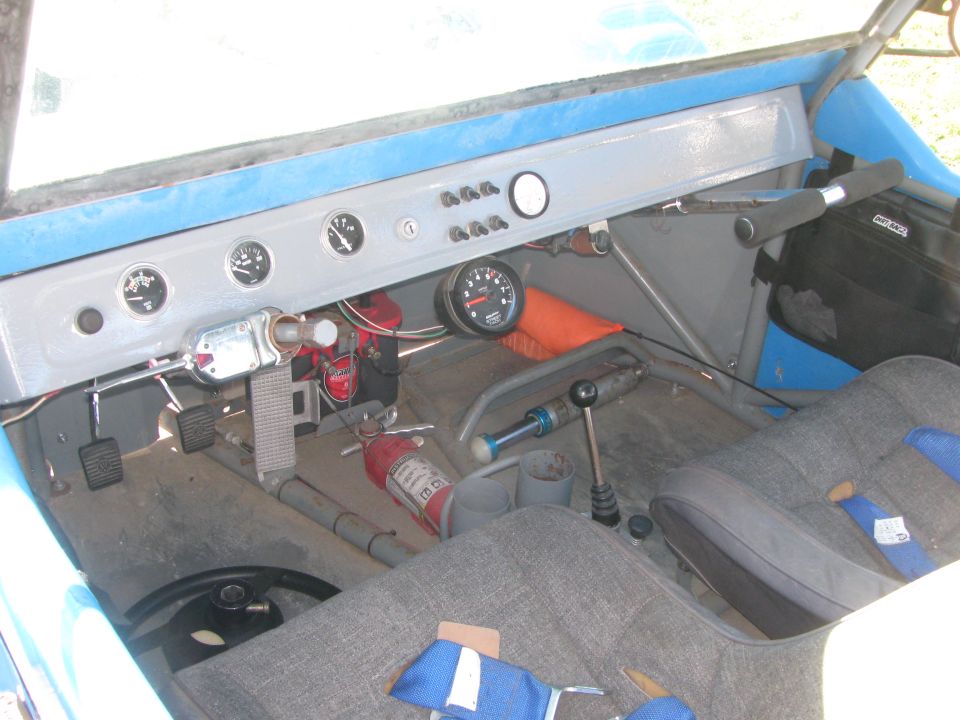 Interior of blue buggy showing painted metal dash with gauges, shifter and fire extinguisher