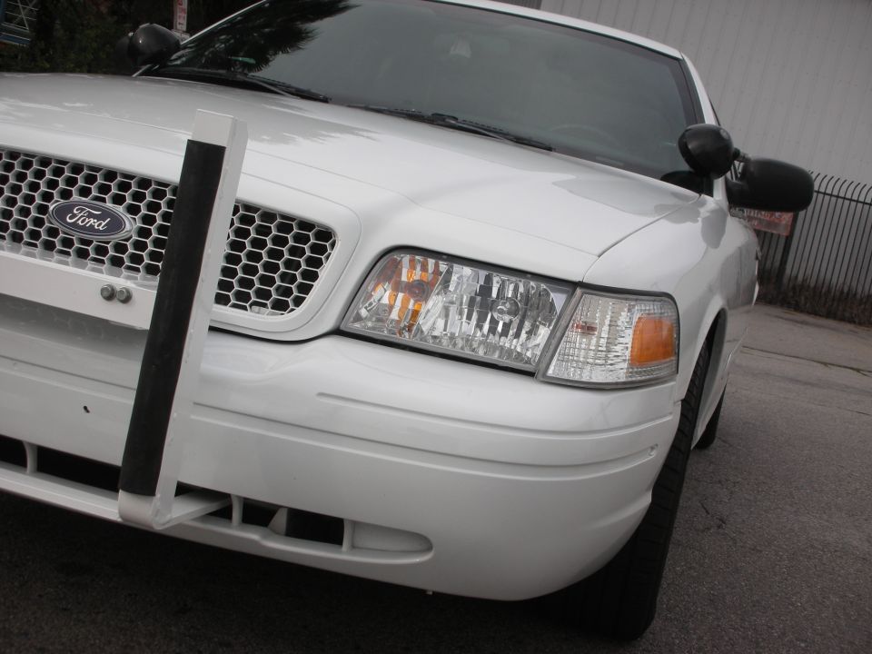 Front view of a white Ford Crown Victoria police car with a push bumper
