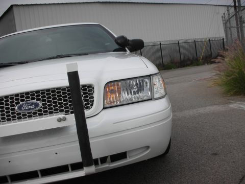 2004 Ford Crown Victoria - Front view of a white 2004 Ford Crown Victoria police car equipped with a push bumper.