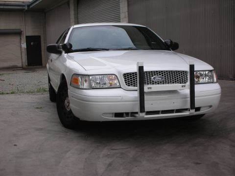 2004 Ford Crown Victoria - Front view of a white 2004 Ford Crown Victoria, equipped with a push bar and a distinctive grille.