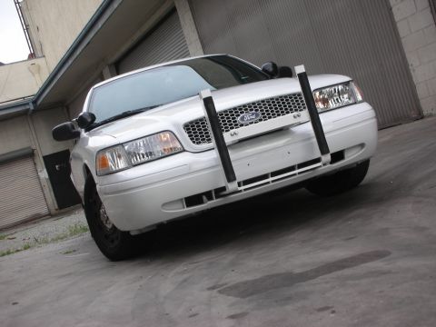 2004 Ford Crown Victoria - White 2004 Ford Crown Victoria with a push bar is parked in front of a garage.