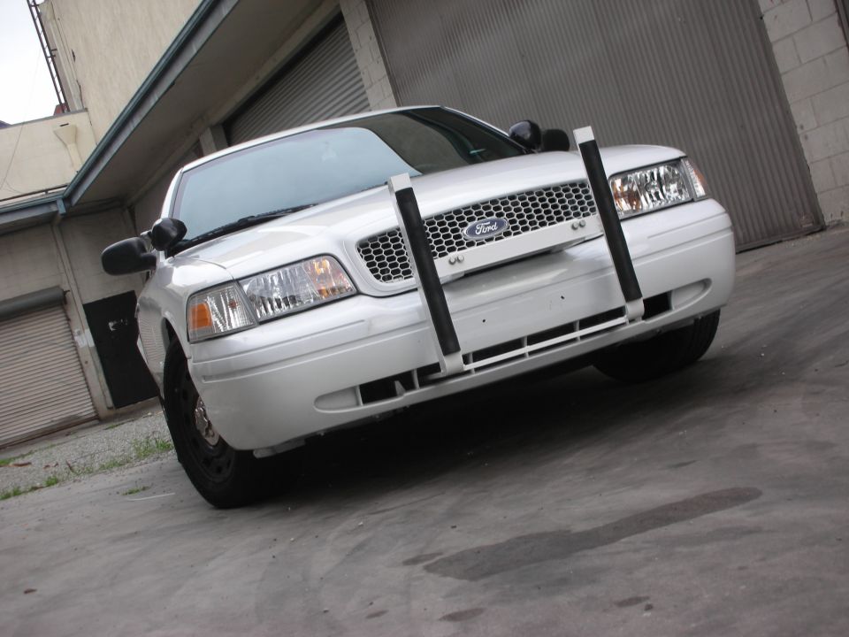 Front view of a white Ford Crown Victoria with a push bar and honeycomb grille