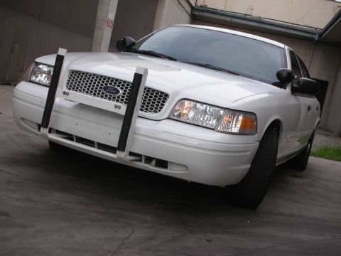 2004 Ford Crown Victoria - A white 2004 Ford Crown Victoria is shown from the front, equipped with a push bar.