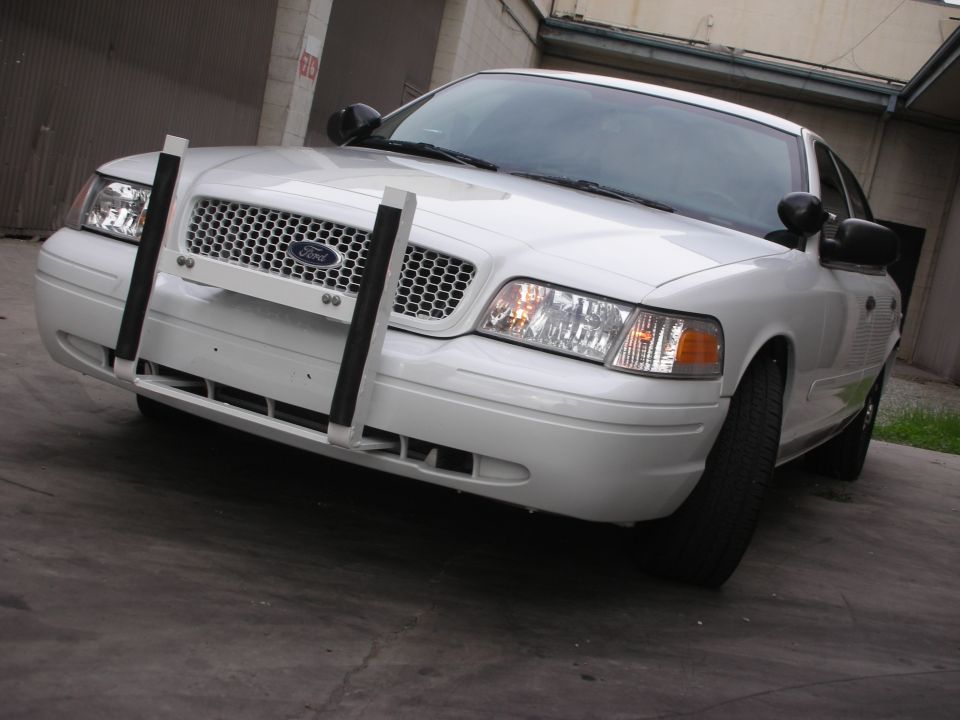 White 2004 Ford Crown Victoria with a push bar, front view, parked on concrete