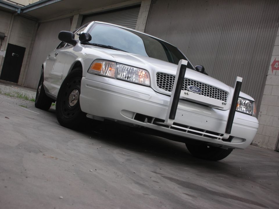 White Ford Crown Victoria with a push bumper, front view